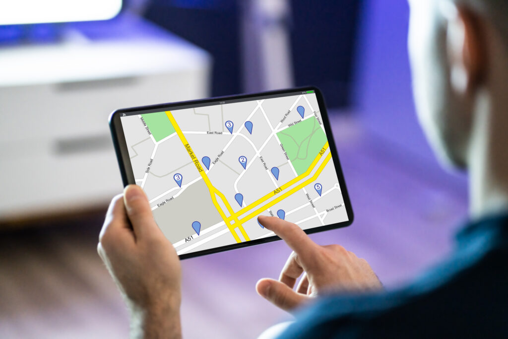 Mann hält GPS-Standortkarte auf Tablet