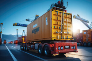 LKW mit gelbem Frachtcontainer auf einem Anhänger im Containerhafen